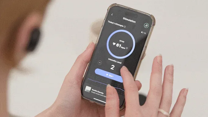A woman wearing the BeCozU earbud, starting a stimulation session in the companion app